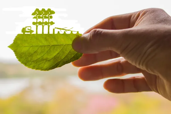 Aus einem Blatt geschnittene Silhouette von abgeholzten Bäumen und Lkw